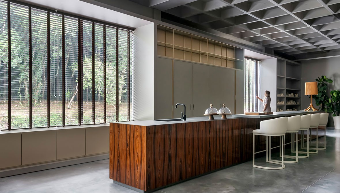 Detalhe da bancada da cozinha com acabamento em madeira de demolição e cuba preta.